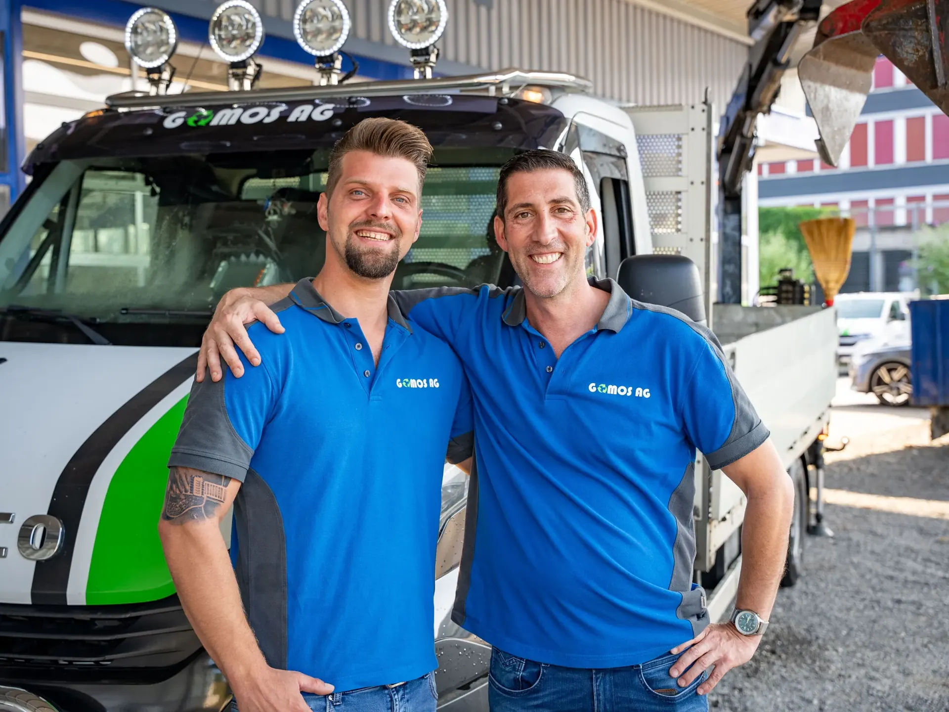 Zwei Mitarbeiter der Gomos AG vor einem Firmenlastwagen